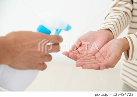 手のアルコール消毒をする中学生の女の子 129454722