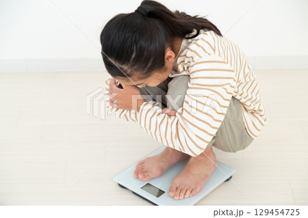 体重計に乗る中学生の女の子 129454725