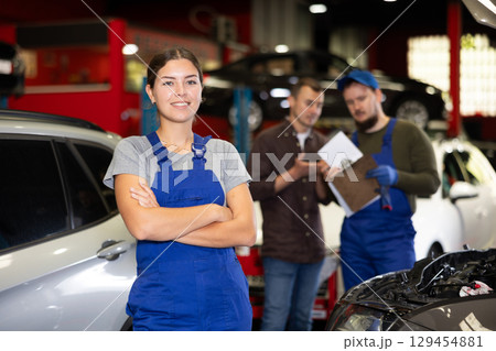 Young female mechanic posing in car service station Young female mechanic posing in car service station 129454881