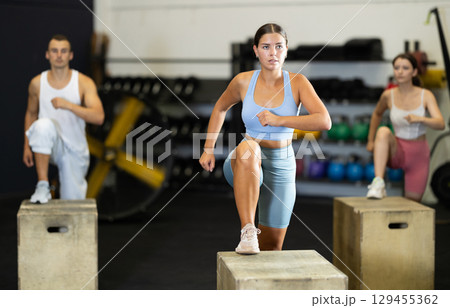 Young woman training with crossfit box 129455362