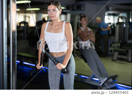 Young woman training with straps in gym Young woman training with straps in gym 129455401