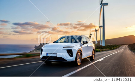 Electric car driving on road near wind turbines at sunset 129455531