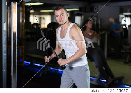 Man in sportswear training on rope loop simulator Man in sportswear training on rope loop simulator 129455687
