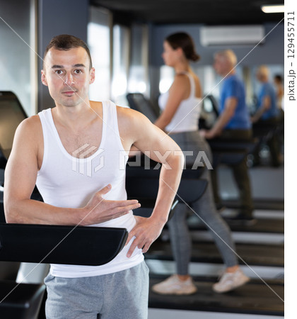 Portrait of sporty man against the background of treadmill in gym 129455711