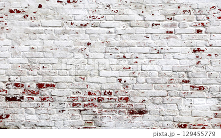 Full horizontal background texture of an aged brick wall with cracked paint of white color. Full pattern for banner with texture of retro brick wall with chipped old paint 129455779