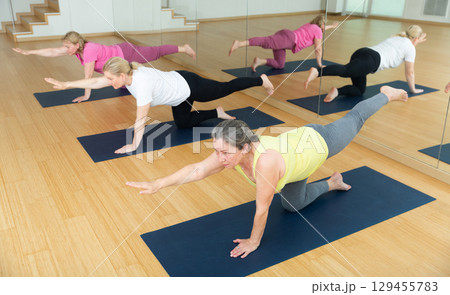 Women are doing extended cat pose 129455783