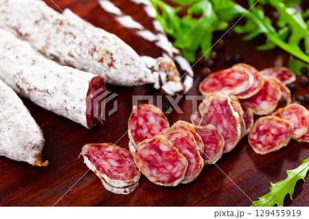 Chopped sausage fuet on wooden table Chopped sausage fuet on wooden table 129455919