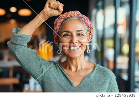 Muslim middle eastern woman in office with raised fist of empowerment, strength and women solidarity, International Womens Day concept Muslim middle eastern woman in office with raised fist of empowerment, strength and women solidarity, International Womens Day concept 129455939