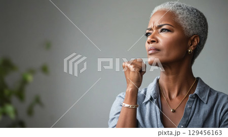 Black mature woman with raised fist of empowerment, strength and women solidarity, International Womens Day, Black History Month concept 129456163