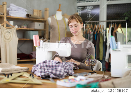 Woman tailor working at sewing machine 129456167