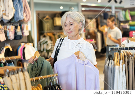 Woman flips through racks of hoodies Woman flips through racks of hoodies 129456393