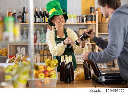 Young woman seller offers beer to buyer Young woman seller offers beer to buyer 129456472