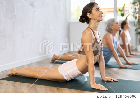 Young woman performing stretching asana Urdhva Mukha Shvanasana 129456600