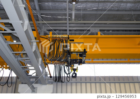 Overhead crane or lifting equipment inside factory or warehouse. 129456953