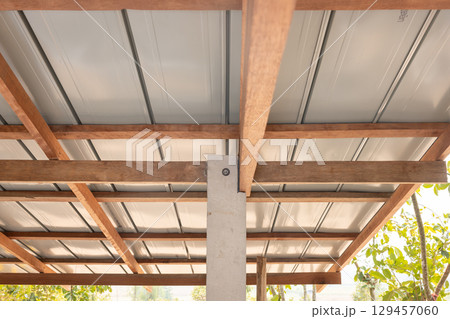 Roof under construction with metal sheet and wood structure. 129457060