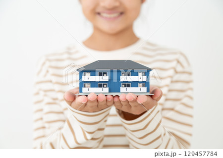 アパートの住宅模型を持つ女子中学生の手元 129457784