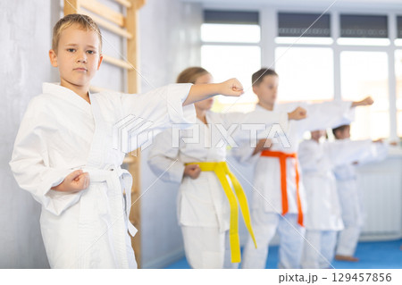 Children students repeat position and perform sequence of punches and painful techniques kata Children students repeat position and perform sequence of punches and painful techniques kata 129457856