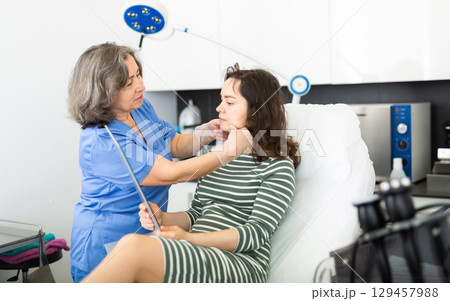 Qualified beautician examining female face skin after procedure Qualified beautician examining female face skin after procedure 129457988