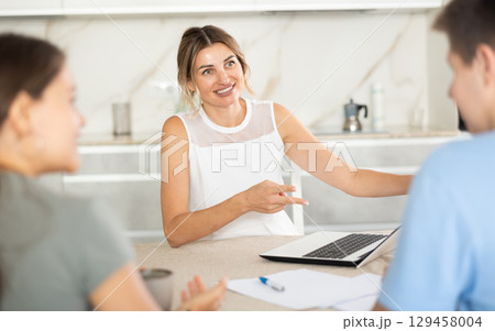 Woman manager tells clients about specifics of design of microloan, about benefits and advantages 129458004