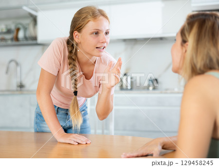 Teenage daughter enthusiastically tells unrecognizable mother about planned vacation with friends 129458245