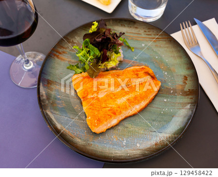 Fried salmon fillet with fresh greens salad Fried salmon fillet with fresh greens salad 129458422