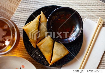 Potato curry samosas served with sause at plate Potato curry samosas served with sause at plate 129458538