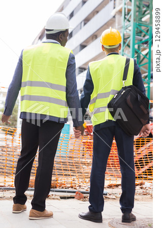 Engineers standing hand in hand on construction site 129458899