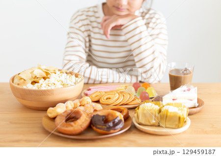 たくさんのお菓子を見て喜ぶ中学生の女の子 129459187