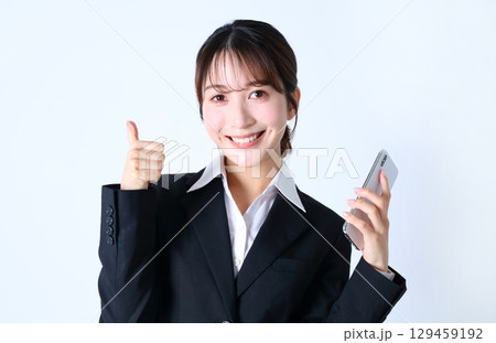 スマホとポジティブな女性会社員のイメージ 129459192