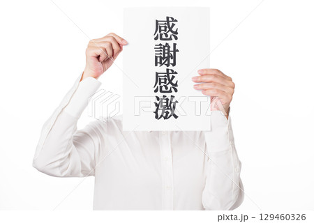 感謝感激と書かれた紙を持つ白いシャツを着た人物 129460326