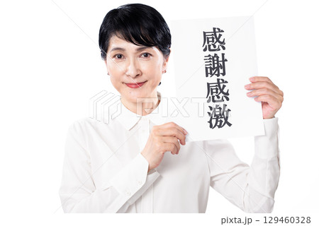 感謝感激と書かれた紙を持ち微笑む中年女性 129460328