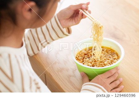 部屋でカップラーメンを食べる中学生の女の子 部屋でカップラーメンを食べる中学生の女の子 129460396