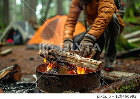 焚き火を準備するキャンパーと森のテント 焚き火を準備するキャンパーと森のテント 129460992