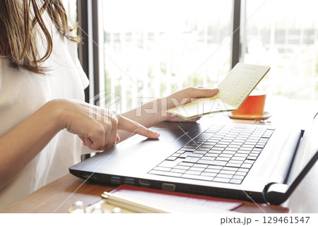 銀行の取引履歴をPCで管理する女性 129461547