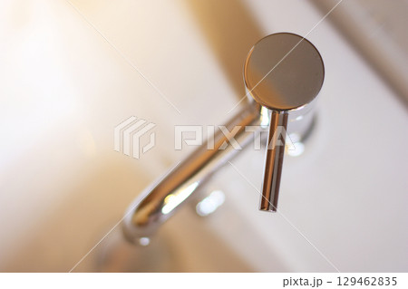 Closed up Silver Steel Basin Faucet with sunlight on top view in the bathroom. 129462835