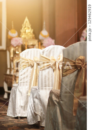Beautiful chairs decoration with ribbon in wedding event hall, selective focus. 129462919