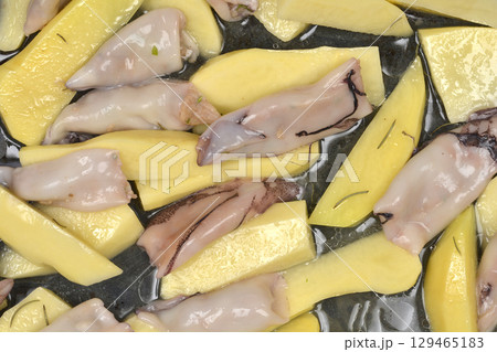Potato wedges and small stuffed squids 129465183