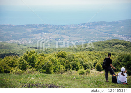 Tourists look at the landscape, mountains and forest Tourists look at the landscape, mountains and forest 129465354