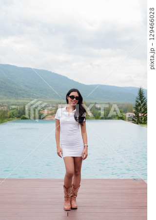 Asian woman in white polo shirt near swimming pool, outdoor nature, summer holiday portrait Asian woman in white polo shirt near swimming pool, outdoor nature, summer holiday portrait 129466028
