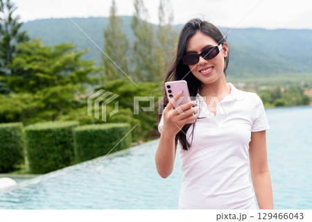 Asian woman in white polo shirt near swimming pool, outdoor nature, summer holiday portrait Asian woman in white polo shirt near swimming pool, outdoor nature, summer holiday portrait 129466043