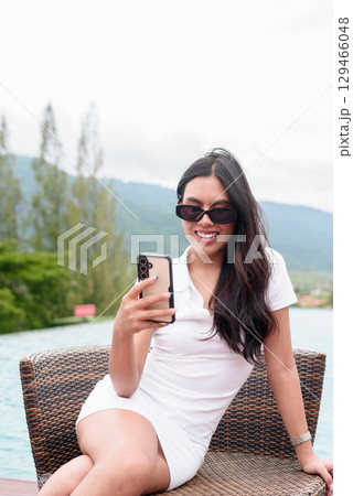 Asian woman in white polo shirt near swimming pool, outdoor nature, summer holiday portrait Asian woman in white polo shirt near swimming pool, outdoor nature, summer holiday portrait 129466048
