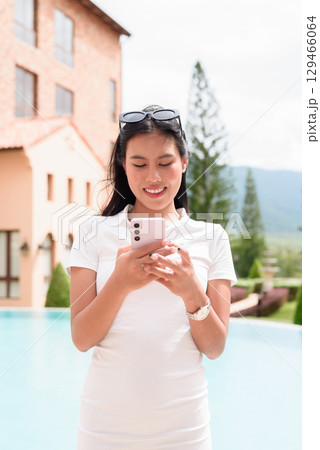 Asian woman in white polo shirt near swimming pool, outdoor nature, summer holiday portrait Asian woman in white polo shirt near swimming pool, outdoor nature, summer holiday portrait 129466064