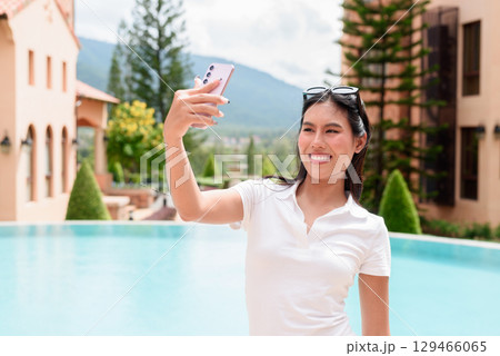 Asian woman in white polo shirt near swimming pool, outdoor nature, summer holiday portrait Asian woman in white polo shirt near swimming pool, outdoor nature, summer holiday portrait 129466065
