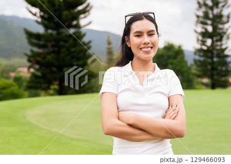 Asian woman in white polo shirt at golf course, on greenery field, tourist outdoor lifestyle 129466093
