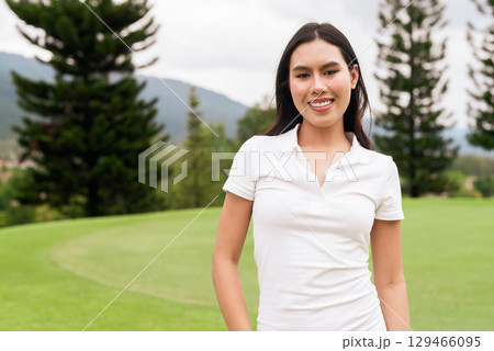 Asian woman in white polo shirt at golf course, on greenery field, tourist outdoor lifestyle 129466095