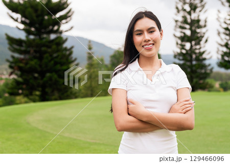 Asian woman in white polo shirt at golf course, on greenery field, tourist outdoor lifestyle 129466096
