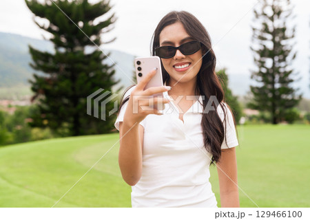 Asian woman in white polo shirt at golf course, on greenery field, tourist outdoor lifestyle Asian woman in white polo shirt at golf course, on greenery field, tourist outdoor lifestyle 129466100