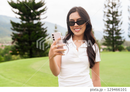 Asian woman in white polo shirt at golf course, on greenery field, tourist outdoor lifestyle Asian woman in white polo shirt at golf course, on greenery field, tourist outdoor lifestyle 129466101