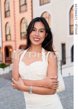 Young Asian woman tourist with long black hair in European style town in portrait travel style 129466194
