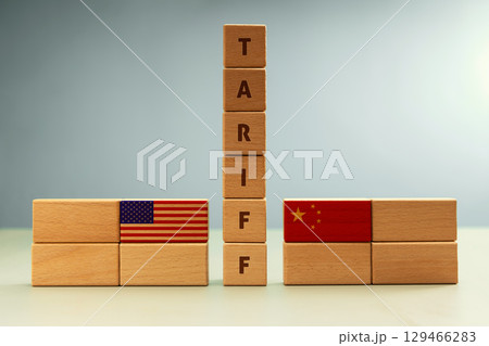 Wooden blocks with U.S. and China flags separated by word TARIFF. Global economic impact of the U.S.-China trade war 129466283